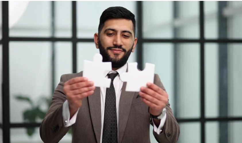 Businessman show white jigsaw in hand business strategy concept